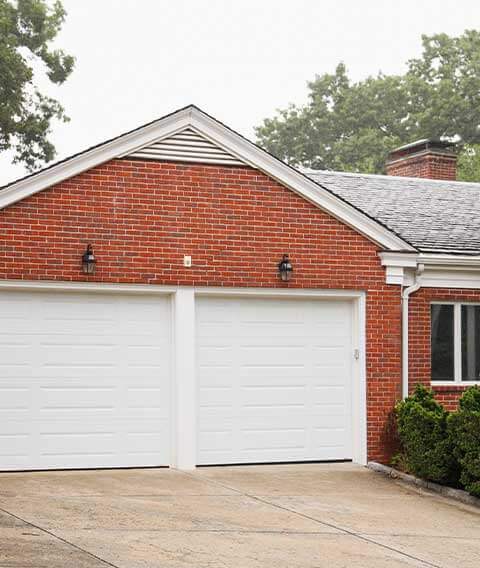 White double garage doors on a brick home